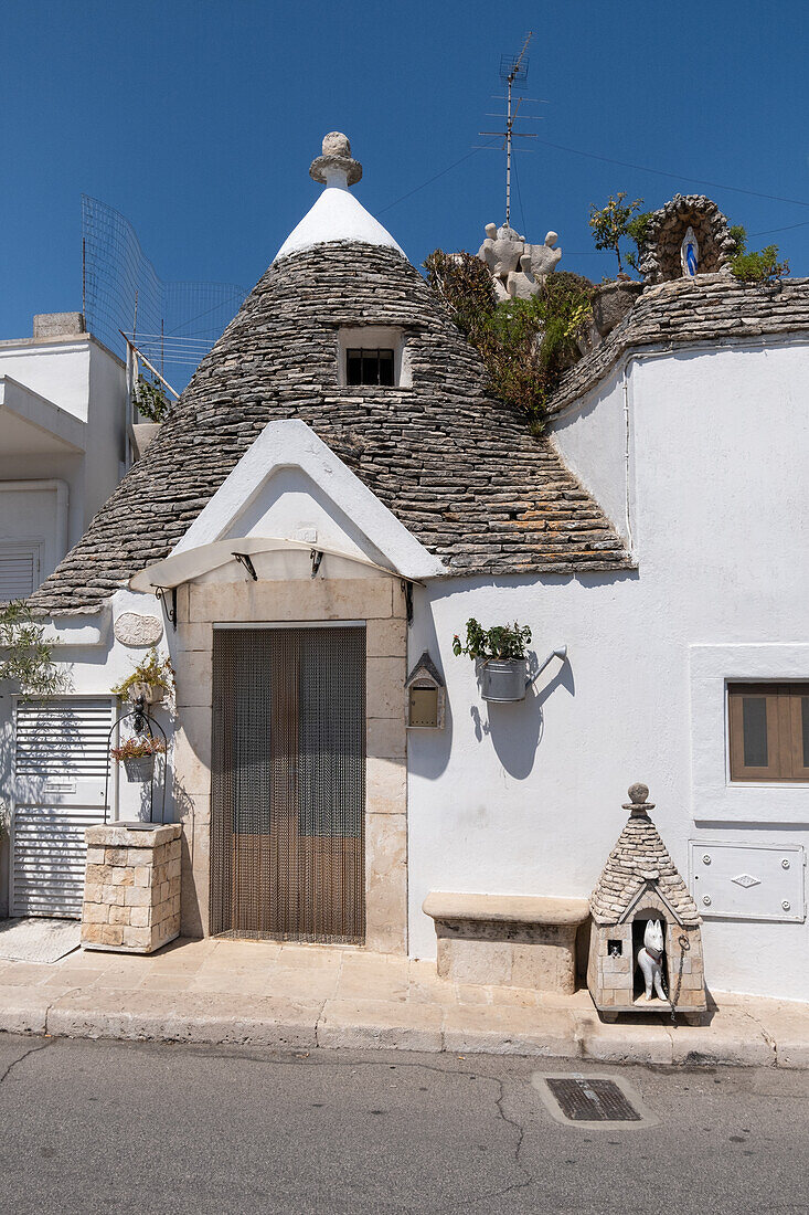 View of a trulli house with doghouse, typical buildings of Alberobello (Unesco World Heritage Site) in summer, municipality of Alberobello, province of Bari, Apulia region, Italy, Europe