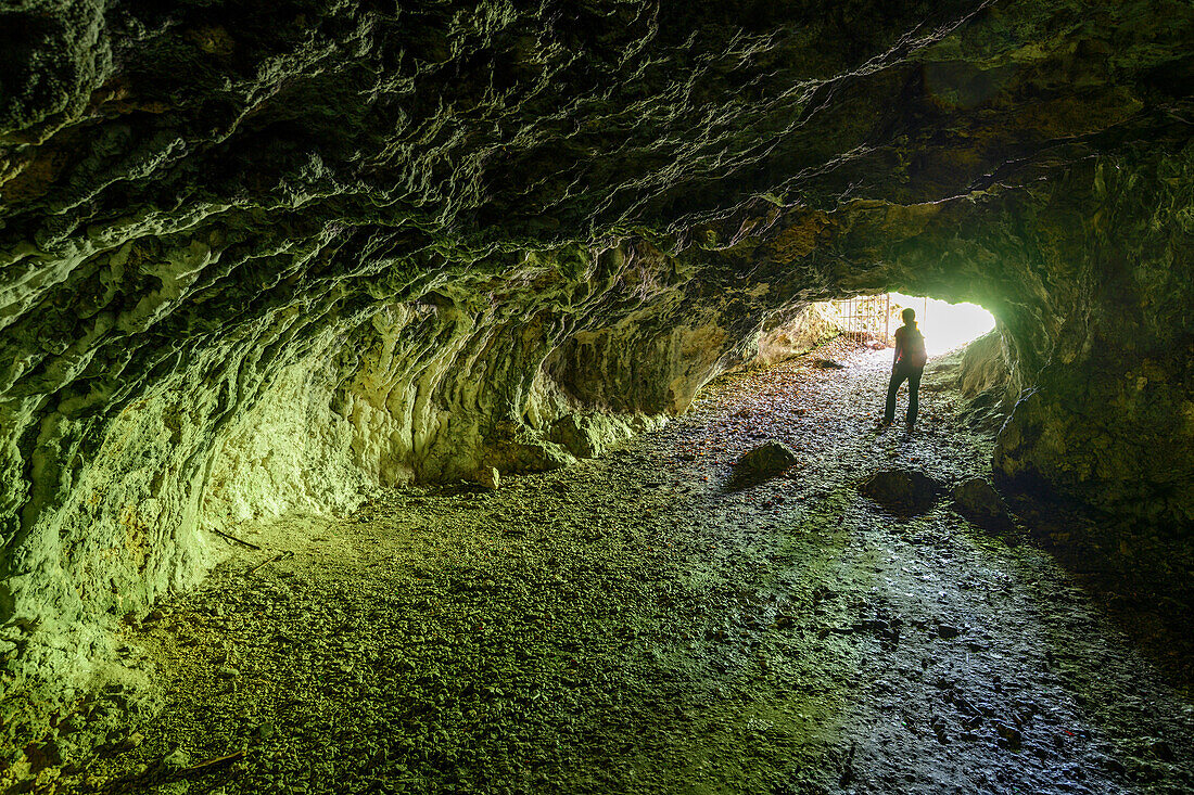 Frau beim Wandern steht in Höhle Finsteres Loch, Rosenstein, Heubach, Schwäbische Alb, Baden-Württemberg, Deutschland