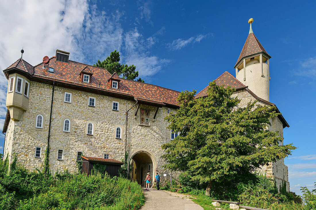 Two people hiking go through archway of Teck Castle, Teck, Swabian Alb, Baden-Württemberg, Germany