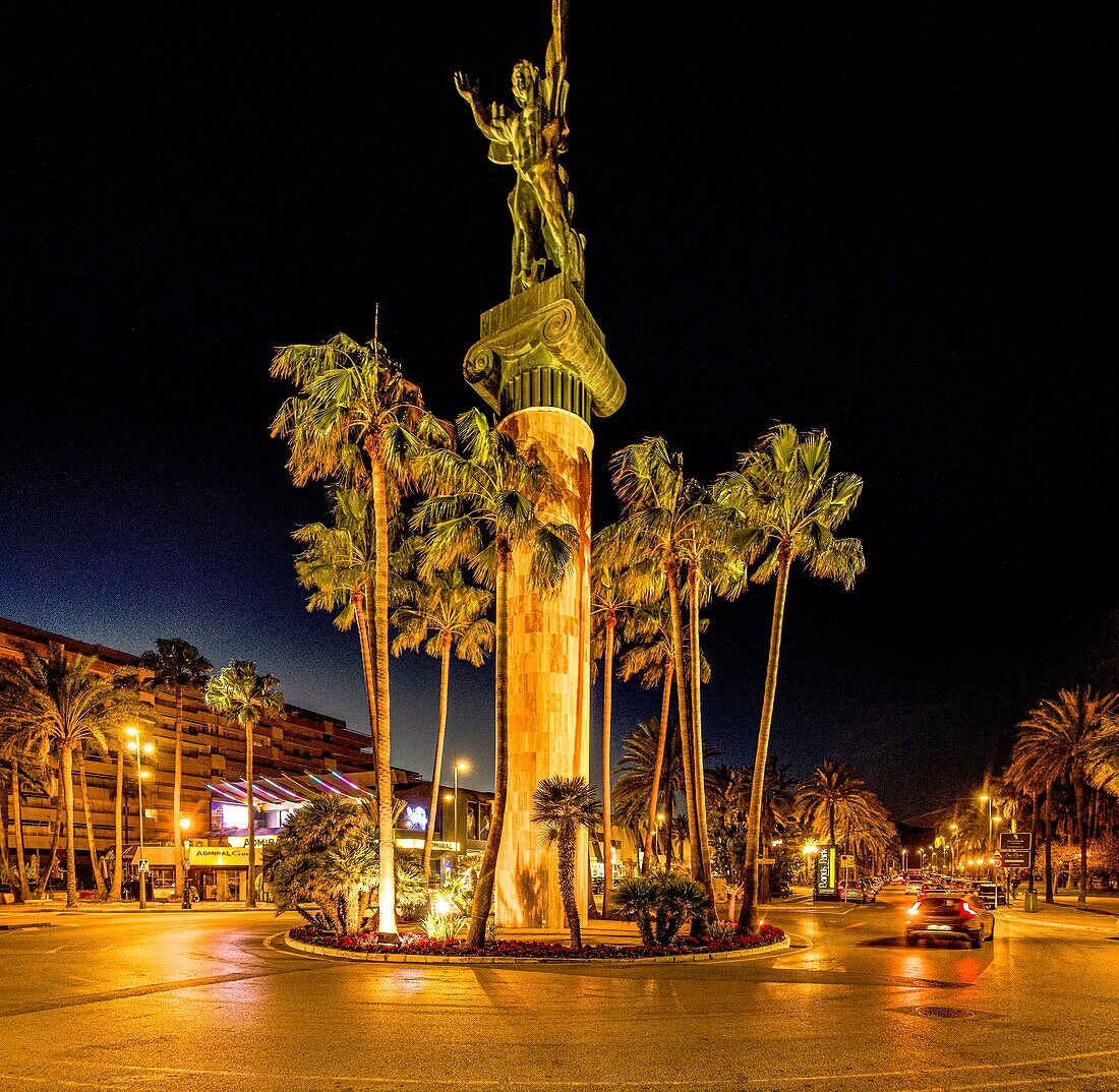  Victoria statue on a boulevard with palm trees at night, Puerto Banús, Marbella, Costa del Sol, Andalusia, Spain 