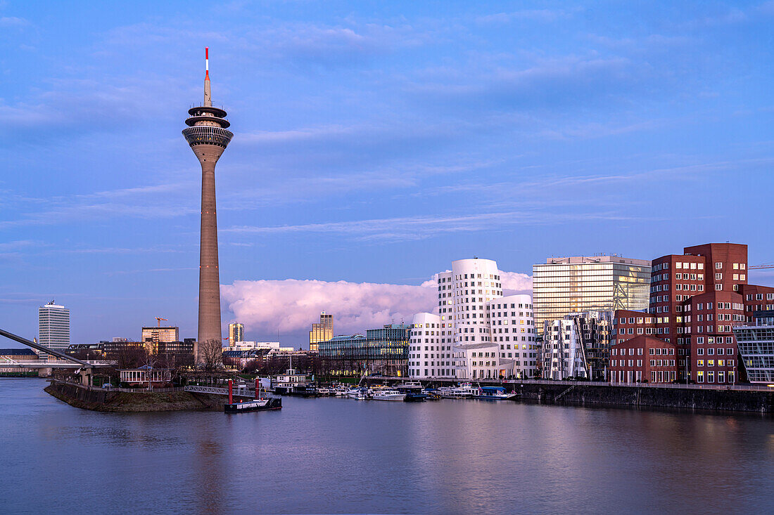  Gehry buildings - Neuer Zollhof at Medienhafen and the Rhine Tower in Düsseldorf at dusk, North Rhine-Westphalia, Germany 
