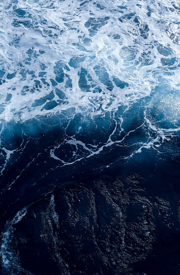 Blue sea on the coast with waves, surf and spray, seen from above