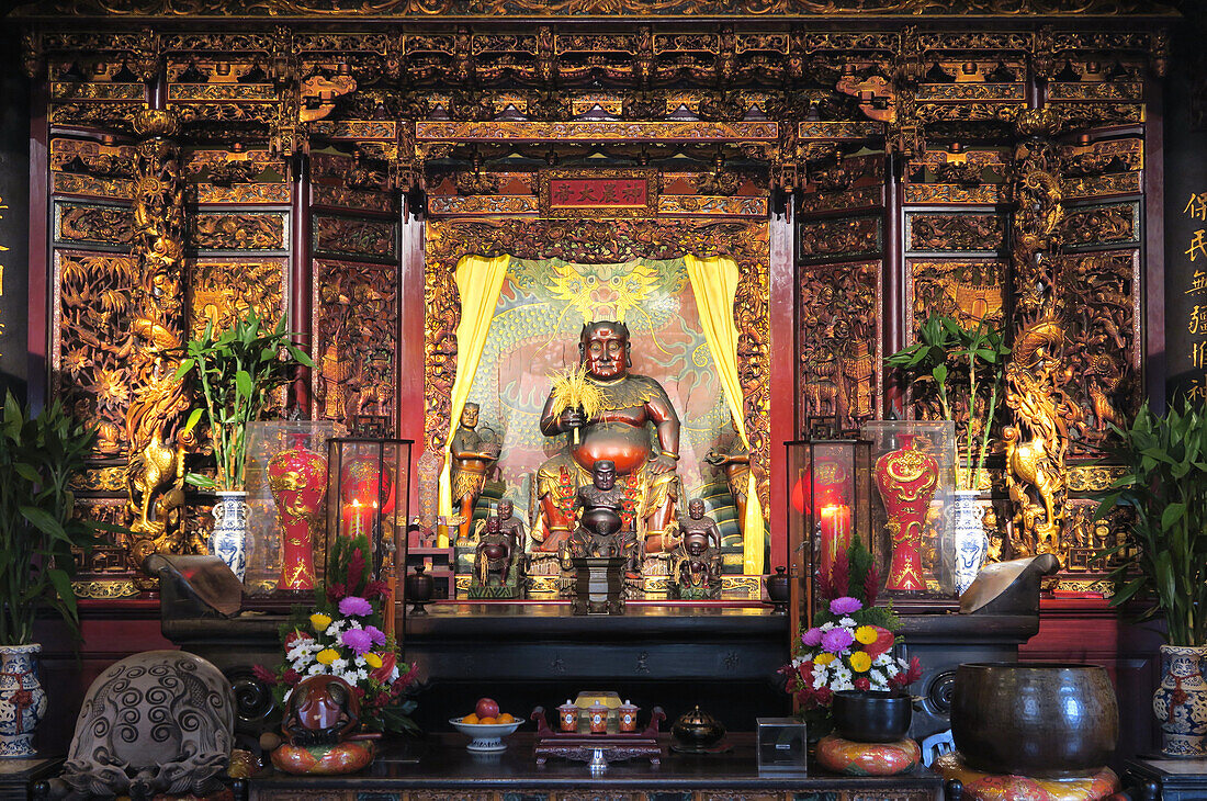Ein reich verzierter Altar mit Blumenschmuck und Opfergaben, Statue von Ur-Kaiser Shennong ("göttlicher Landmann") im Dalongdong Baoan Temple, Taipeh, Taiwan, Asien