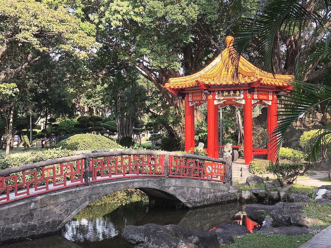  Ornamental pavilion with a pagoda roof and bridge in a park in downtown Taipei. 