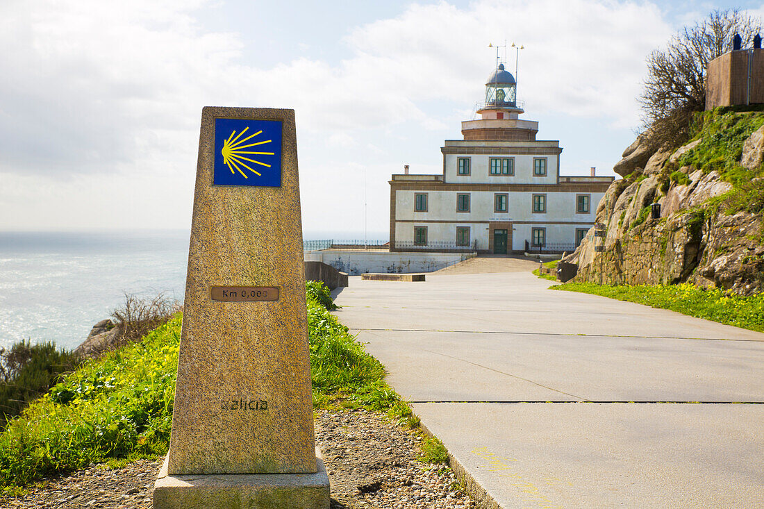 Die Jakobsmuschel am Ende vom Jakobsweg im Hintergrund der Leuchtturm am Kap Finisterre, Galicien, Spanien