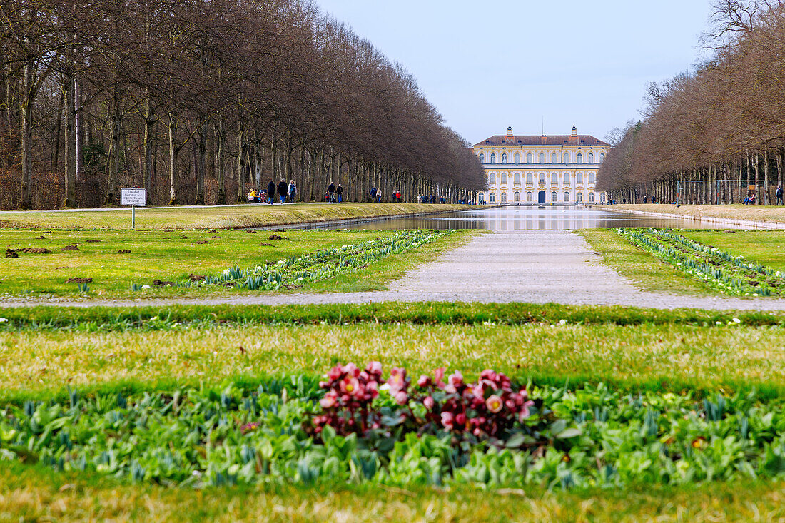  New Schleissheim Palace and palace park with view of the canal and walkers in Oberschleißheim Upper Bavaria, Germany 