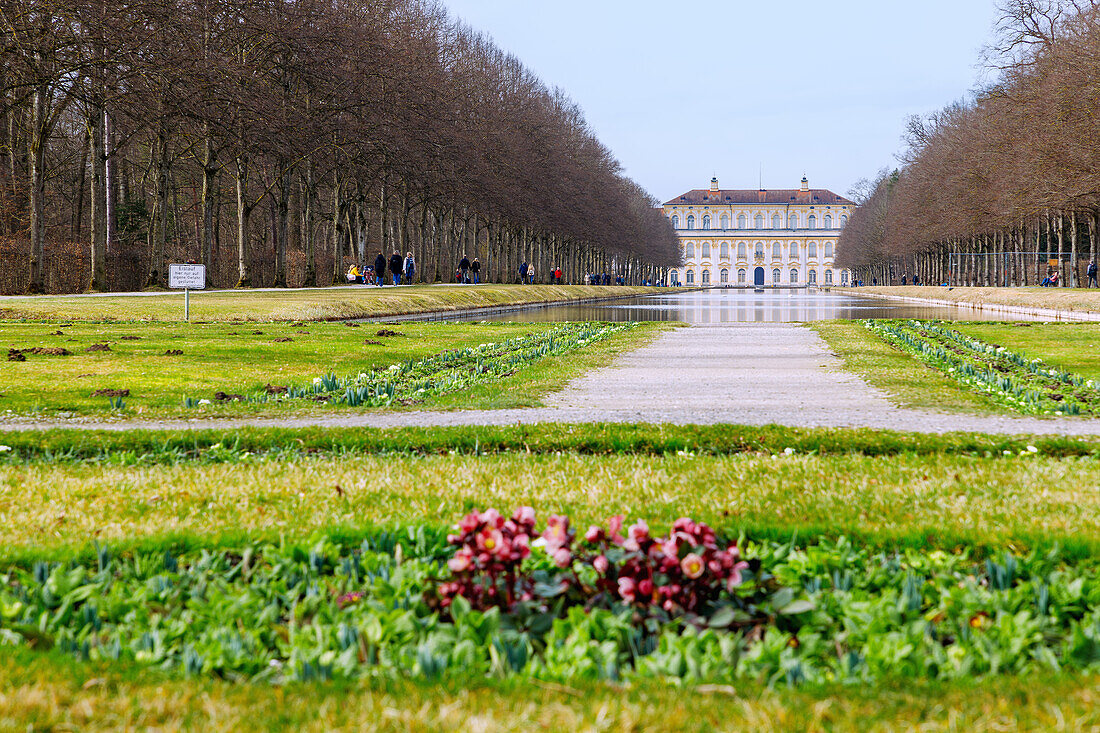 Neues Schloss Schleißheim und Schlosspark mit Blick auf den Kanal und Spaziergänger in Oberschleißheim Oberbayern, Deutschland