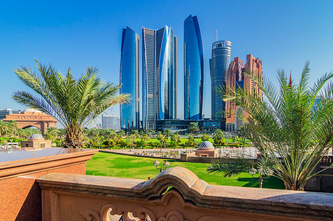 Palmen und Wasserspiele in Grünanlage vor moderner Skyline, in Abu Dhabi, Vereinigte Arabische Emirate, Arabische Halbinsel, Persischer Golf