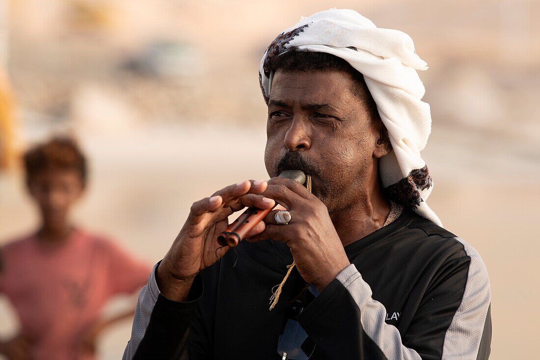 Einheimischer spielt Flöte um Besucher am Pier zu verabschieden, in der Nähe von Hadibu, Insel Sokotra, Jemen, Naher Osten