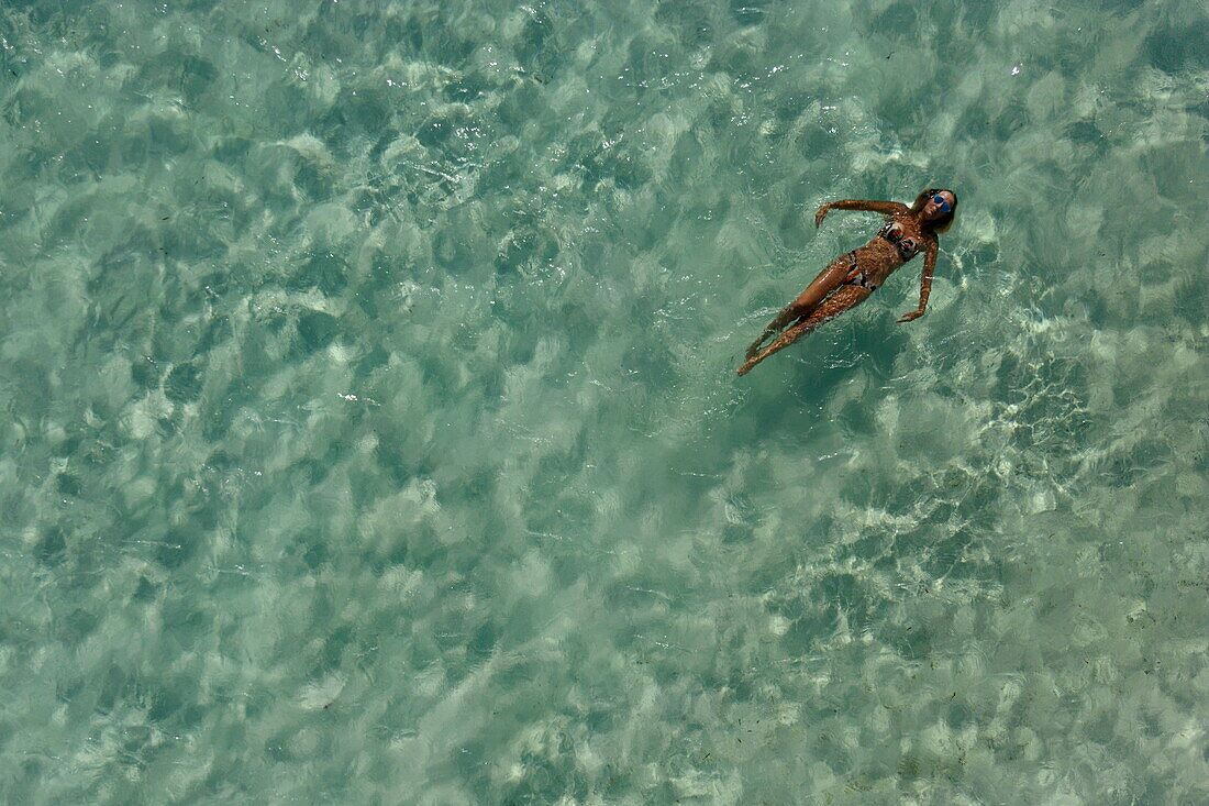  Aerial view of a woman swimming in the crystal clear waters of Bijoutier Island, Bijoutier Island, Alphonse Group, Outer Seychelles, Seychelles, Indian Ocean 