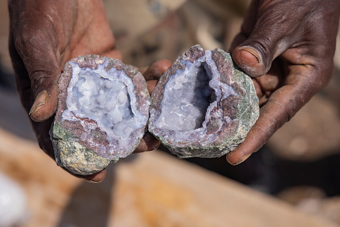 Detail, Hände, die einen Stein mit buntem Mineral halten, in der Nähe von Arta, Dschibuti, Golf von Aden, Ostafrika