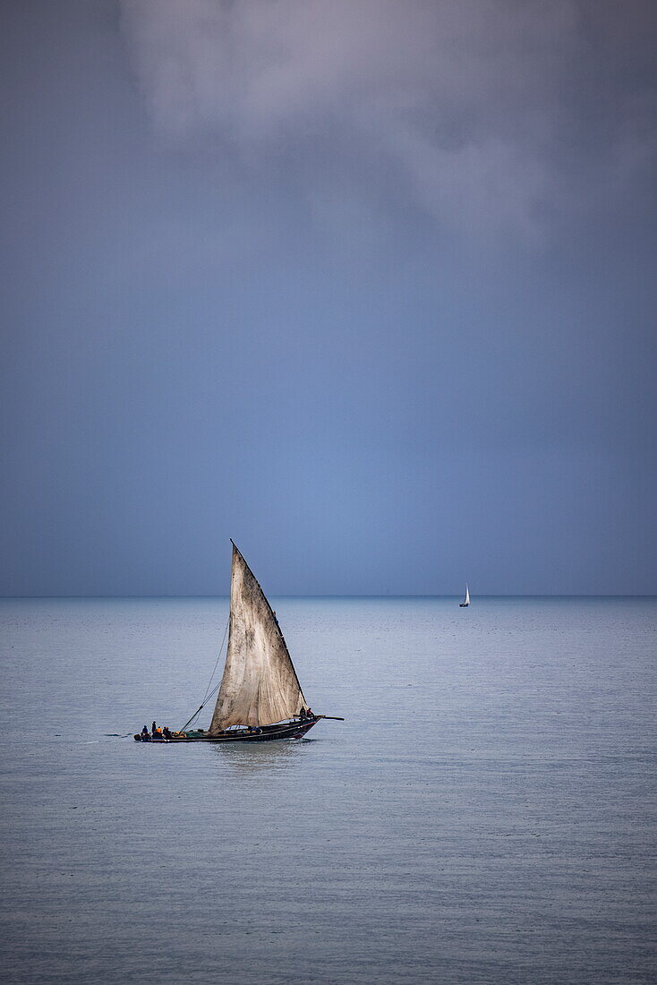 Traditionelles Dhau-Segelboot mit Gewitterwolken im Hintergrund, Stonetown, Sansibar-Stadt, Sansibar, Tansania, Afrika