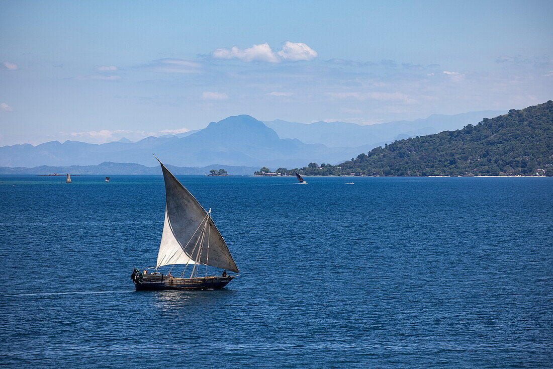  Aerial view of a traditional dhow sailboat with islands in the distance, near Nosy Be, Diana, Madagascar, Indian Ocean 