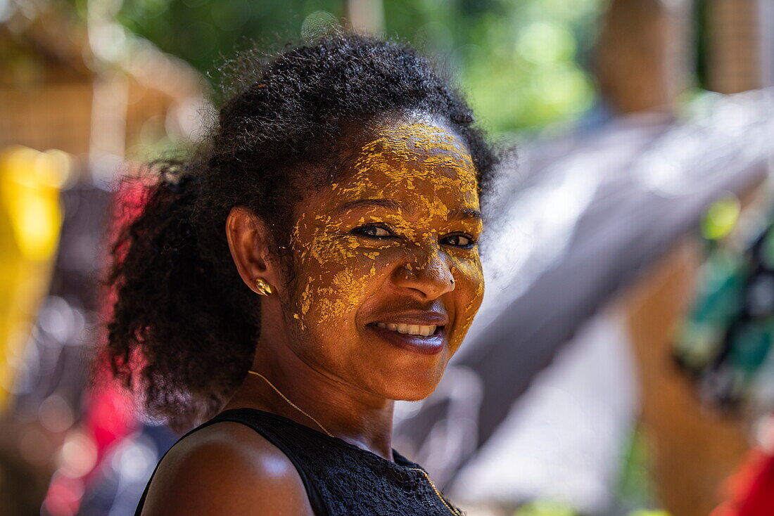  Happy woman using Masonjoany face paint as sunscreen, Nosy Komba, Diana, Madagascar, Indian Ocean 