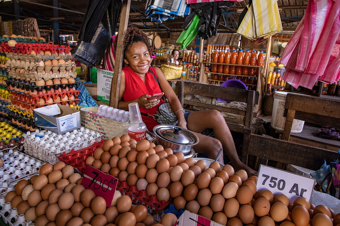 Lächelnde Frau mit Eiern zum Verkauf auf dem Bazary Marolak-Markt, Mahajanga, Boeny, Madagaskar, Indischer Ozean
