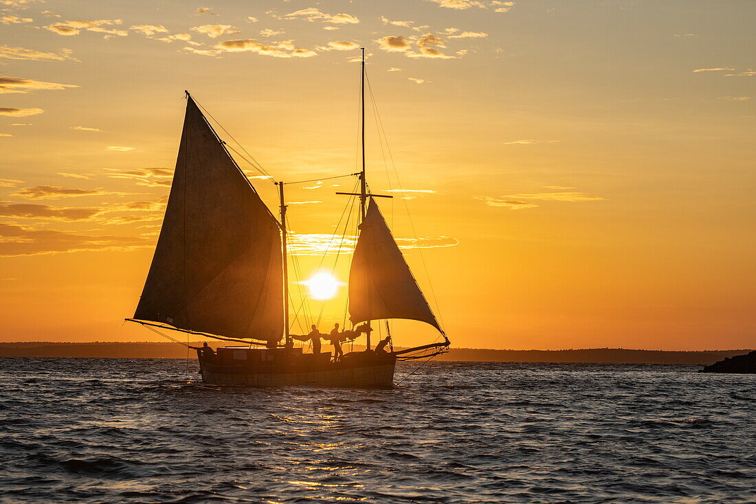 Silhouette eines traditionellen Dhau-Segelboots bei Sonnenuntergang, bei Mahajanga, Boeny, Madagaskar, Indischer Ozean