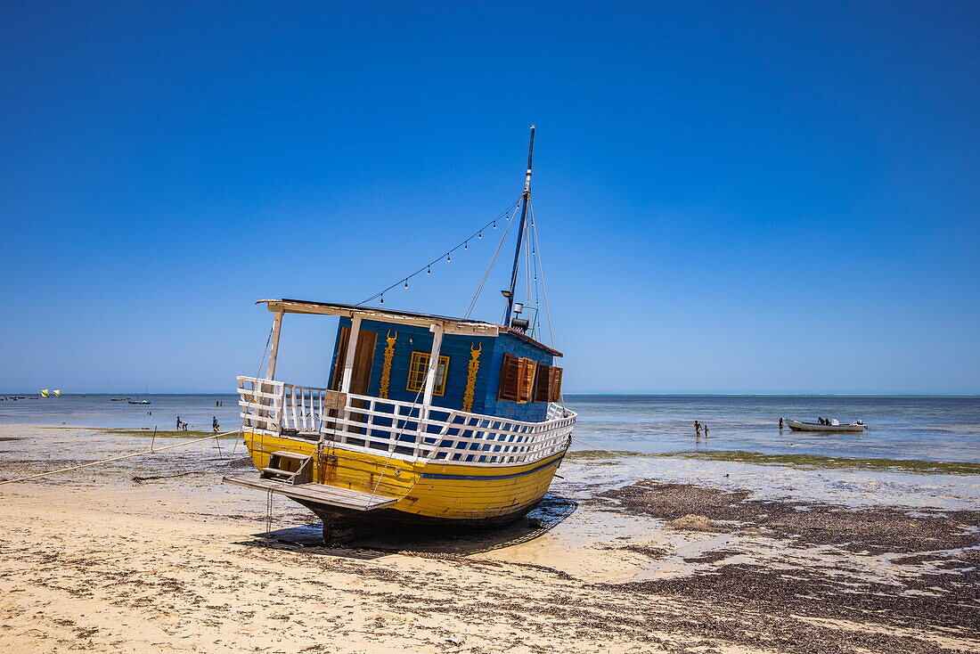 Buntes Fischerboot am Strand bei Ebbe, Toliara, Atsimo-Andrefana, Madagaskar, Indischer Ozean