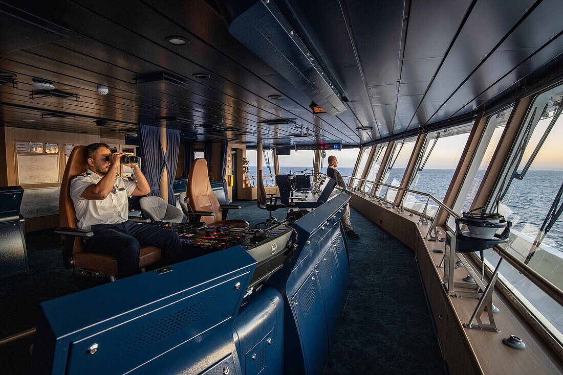  Officer on the bridge of the expedition cruise ship SH Diana (Swan Hellenic) looks through binoculars, near Toliary II, Atsimo-Andrefana, Madagascar, Indian Ocean 