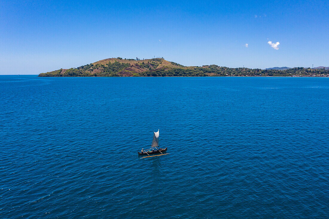  Aerial view of a traditional outrigger canoe with islands in the distance, near Nosy Be, Diana, Madagascar, Indian Ocean 