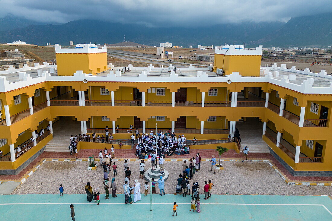 Luftaufnahme eines gelben Schulgebäudes mit Kindern und Besuchern, Hadibu, Insel Sokotra, Jemen, Naher Osten, Vorderasien