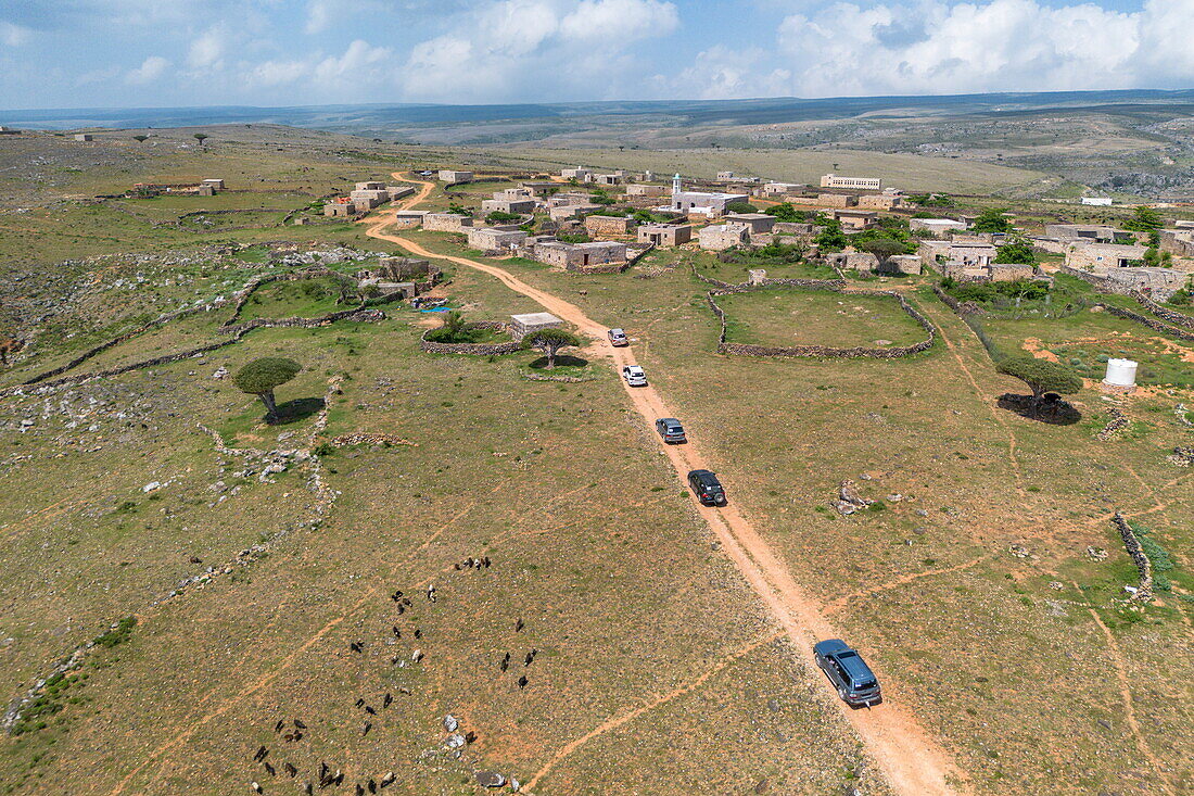  Aerial view of four-wheel drive vehicles on a dirt road near village on Diksam Plateau, Gallaba, Socotra Island, Yemen, Middle East 