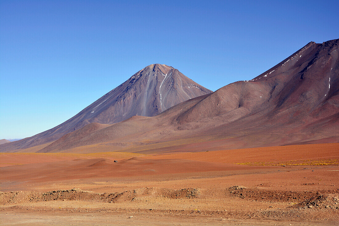 Chile; Nordchile; Region Antofagasta; an der Grenze zu Bolivien; Vulkan Licancabur; im Vordergrund Ausläufer des Vulkan Juriques