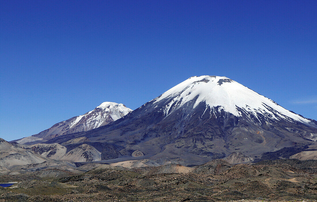 Chile; Nordchile; Region Arica y Parinacota; an der Grenze zu Bolivien; Lauca Nationalpark; Vulkan Parinacota; dahinter der Zwillingsvulkan Pomerape
