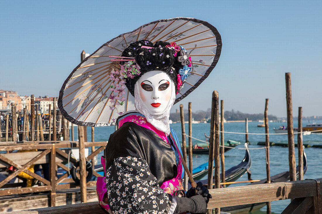  Asian mask on the Grand Canal during Venice Carnival, Venice, Italy 