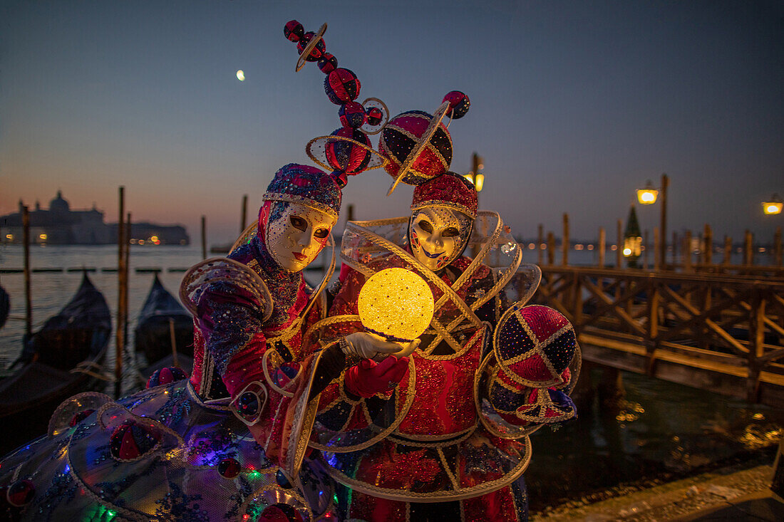  Carnival in Venice: Magnificent harlequin masks in front of the Grand Canal at night, Venice, Italy 