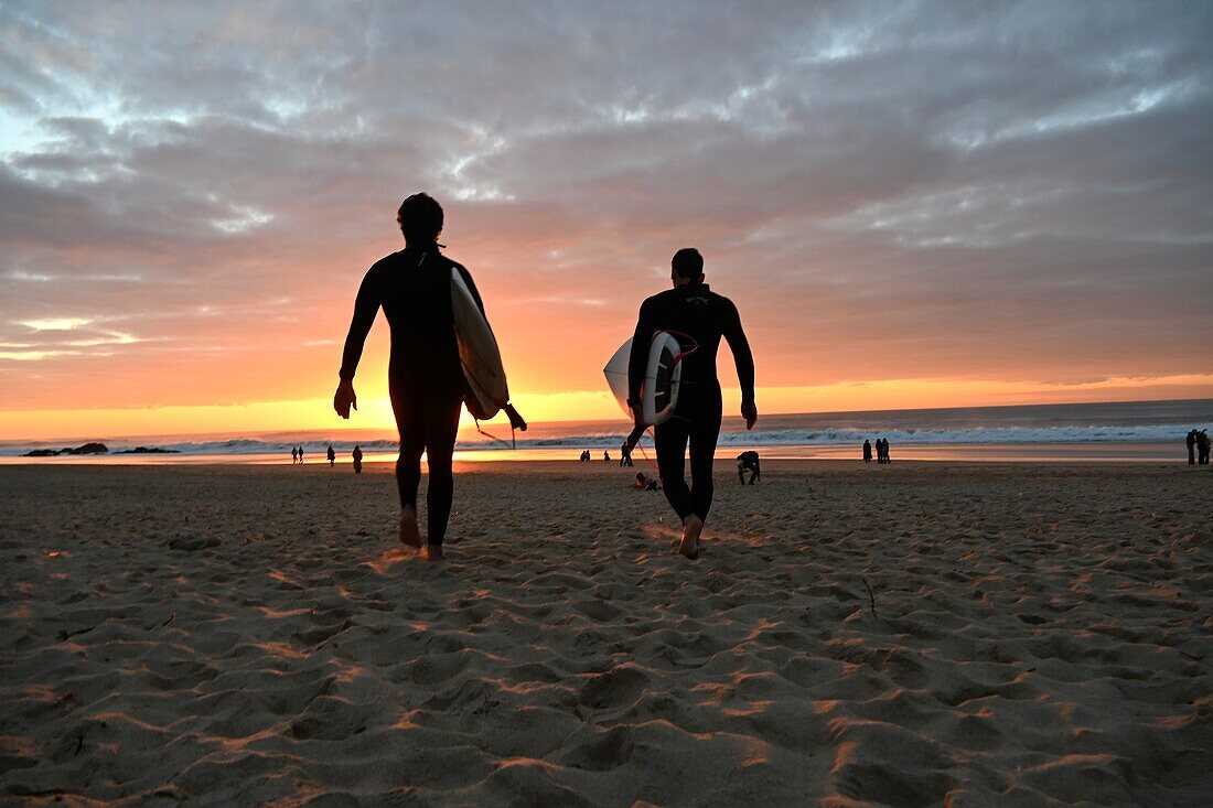 Surfer am Strand Praia do Guincho bei Sonnenuntergang, Atlantik, bei Cascais, Region Lissabon, Portugal
