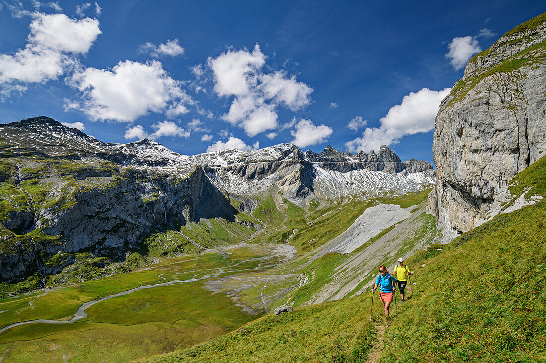  Man and woman hiking with a view of Tschingelhörner and Lower Segnesboden, Tectonic Arena Sardona, Glarus Main Thrust, UNESCO World Natural Heritage Glarus Alps, Glarus Alps, Graubünden, Switzerland  
