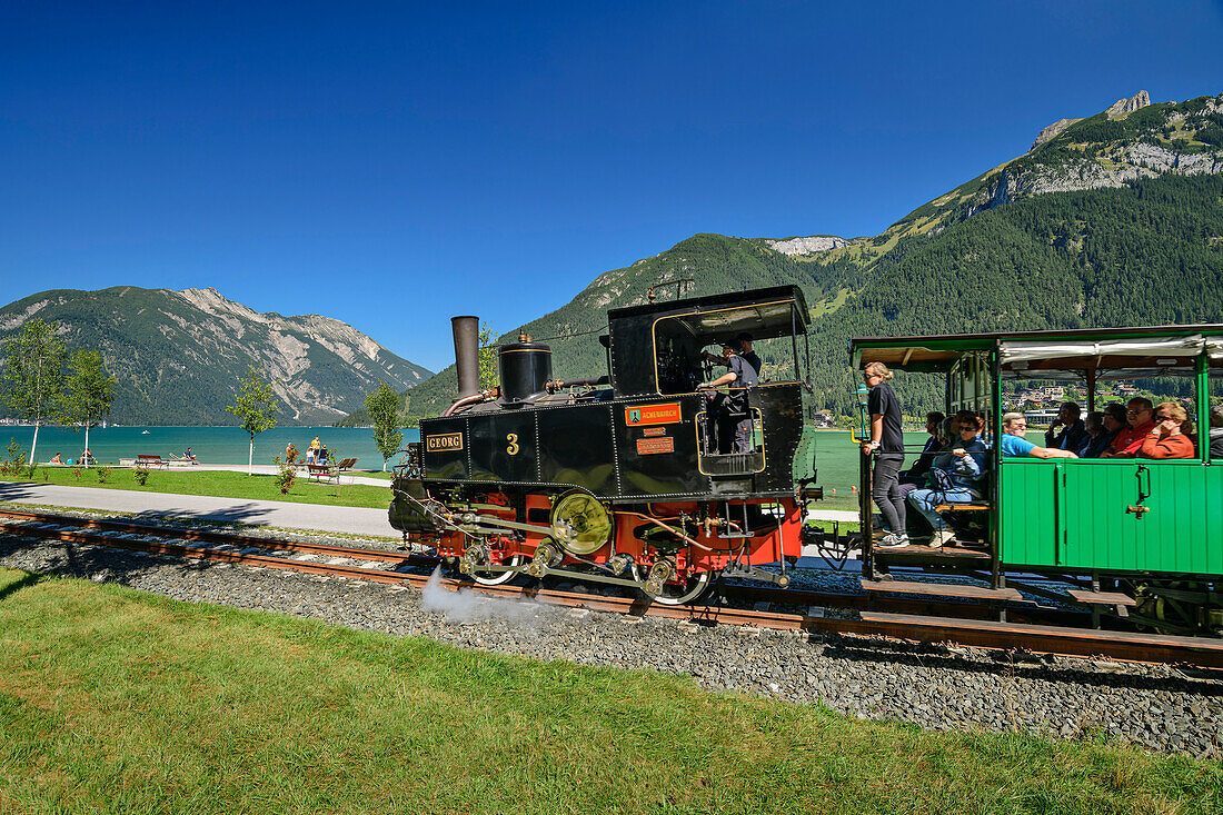 Dampflok der Achenseebahn fährt am Achensee entlang, Karwendel und Rofan im Hintergrund, Achensee, Tirol, Österreich