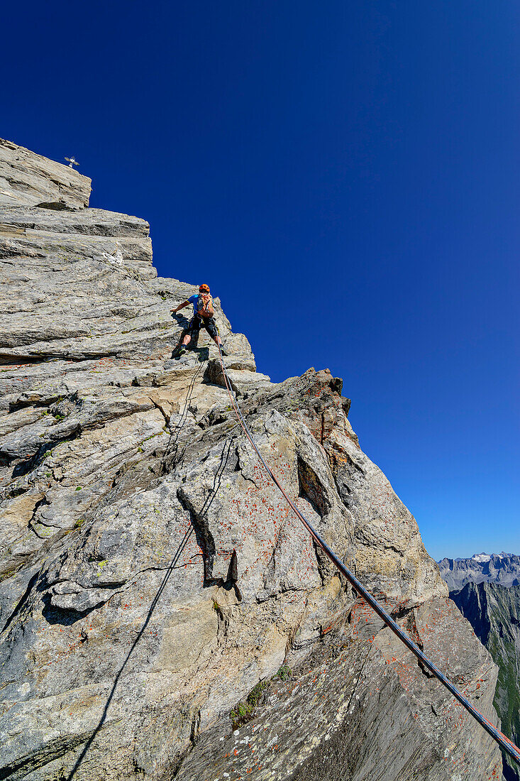 Mann klettert durch Felswand auf Zsigmondyspitze, Zsigmondyspitze, Zillertaler Alpen, Naturpark Zillertaler Alpen, Tirol, Österreich
