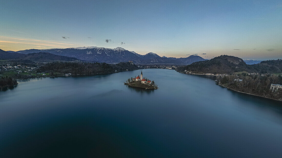 Panoramaaufnahme Bleder Sees und der verschneiten Berge kurz nach Sonnenuntergang in Bled, Slowenien, Europa.