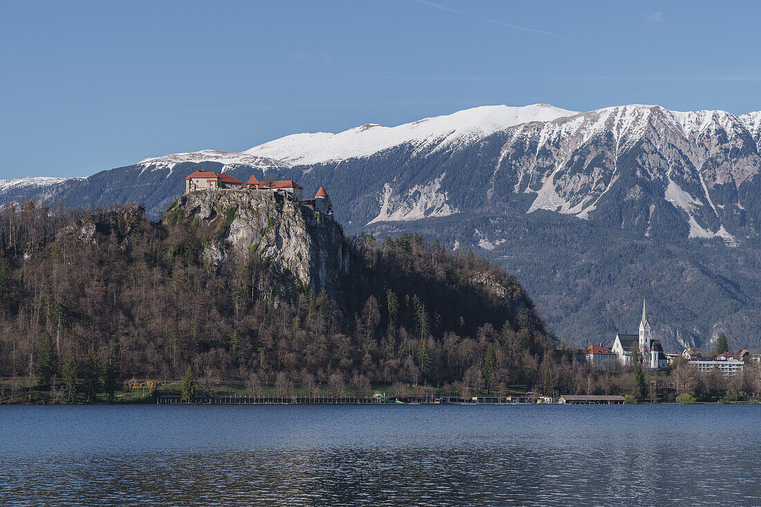 Blick auf die Bleder Burg und das dahinter liegende verschneite Gebirge in Bled, Slowenien, Europa.
