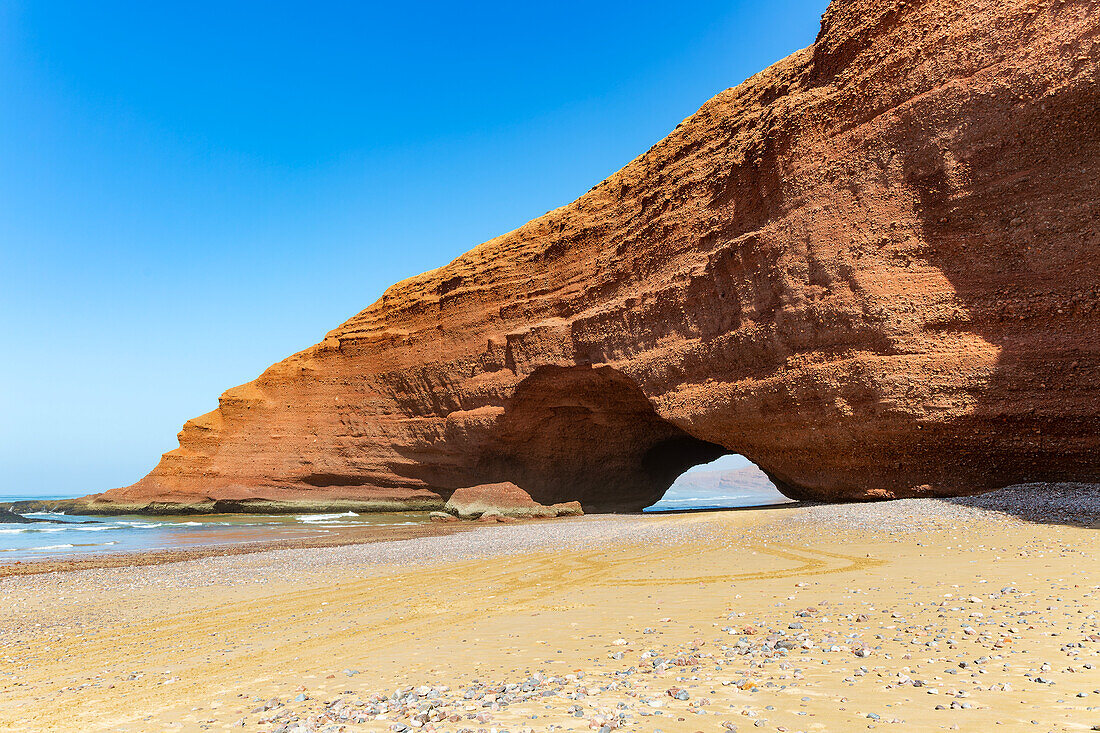 Natural rock coastal arch erosional landform on beach, Legzira, southern Morocco, north Africa