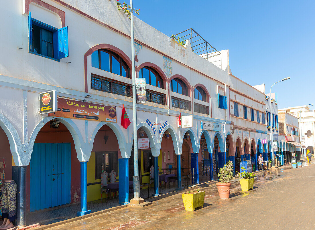 Historische Gebäude, Geschäfte und Hotels in der Einkaufsstraße mit Arkaden im Stadtzentrum, Mirleft, Südmarokko, Nordafrika