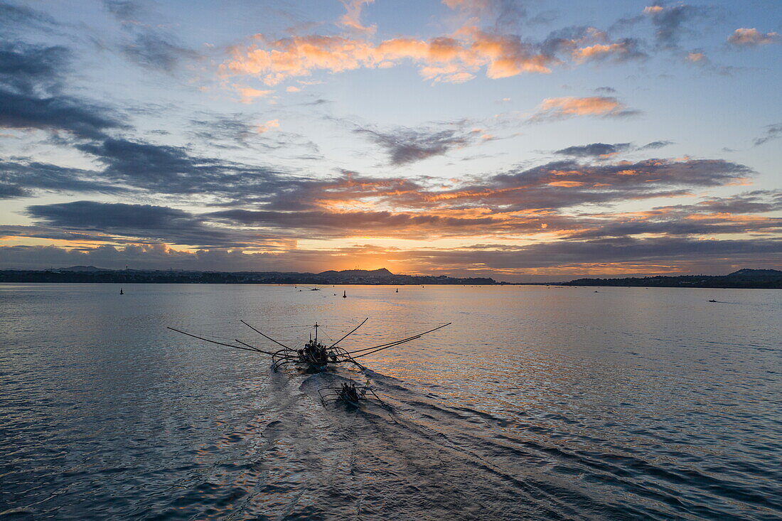  Aerial view of a traditional Bangka outrigger canoe fishing boat at sunrise, Tagbilaran, Bohol, Philippines 