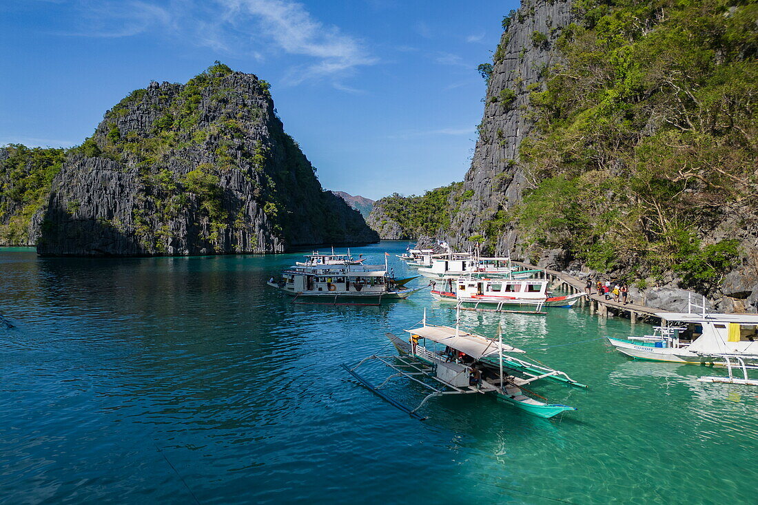  Aerial view of Bangka outrigger canoe tour boats and karst island in lagoon near Kayangan Lake, Coron, Palawan, Philippines 