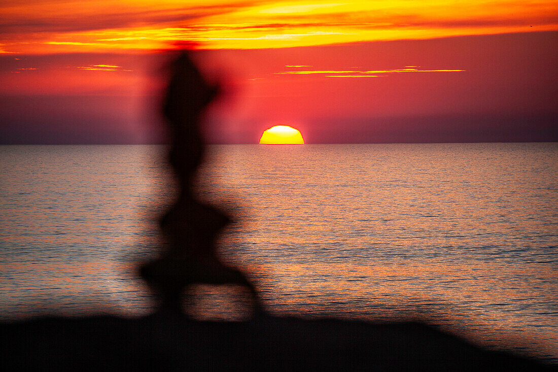 Steinskulptur am Meer bei Sonnenuntergang