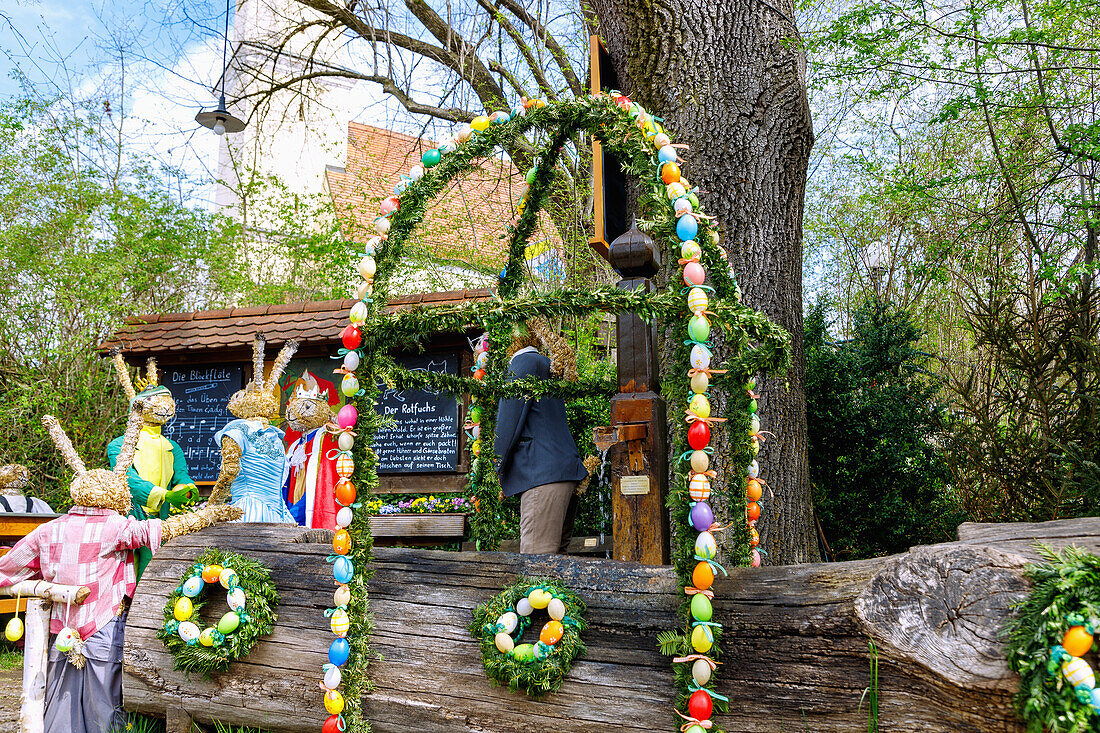 Häschenschule und geschmückter Osterbrunnen am Dorfplatz von Ottenhofen in Oberbayern in Deutschland