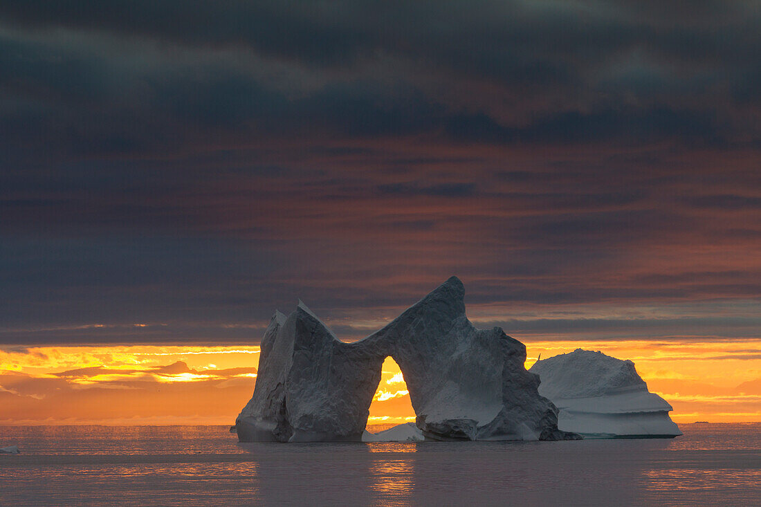 Eisberg mit Torbogen im Sonnenuntergang, Kangia Eisfjord, UNESCO Weltnaturerbe, Disko-Bucht, West-Groenland, Grönland