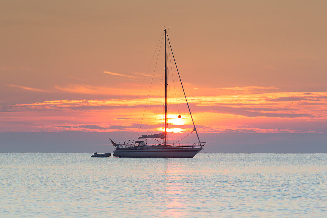 Segelboot auf der Ostsee im Sonnenaufgang, Schleswig-Holstein, Deutschland