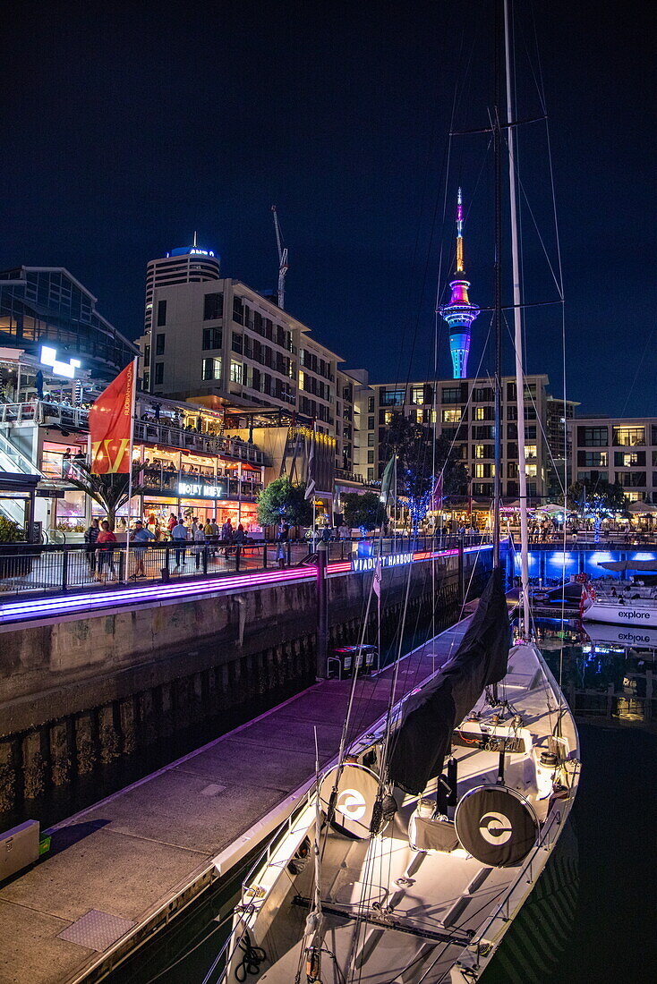  Sailboat in Viaduct Basin with bars and illuminated Sky Tower at night, Auckland, North Island, New Zealand 