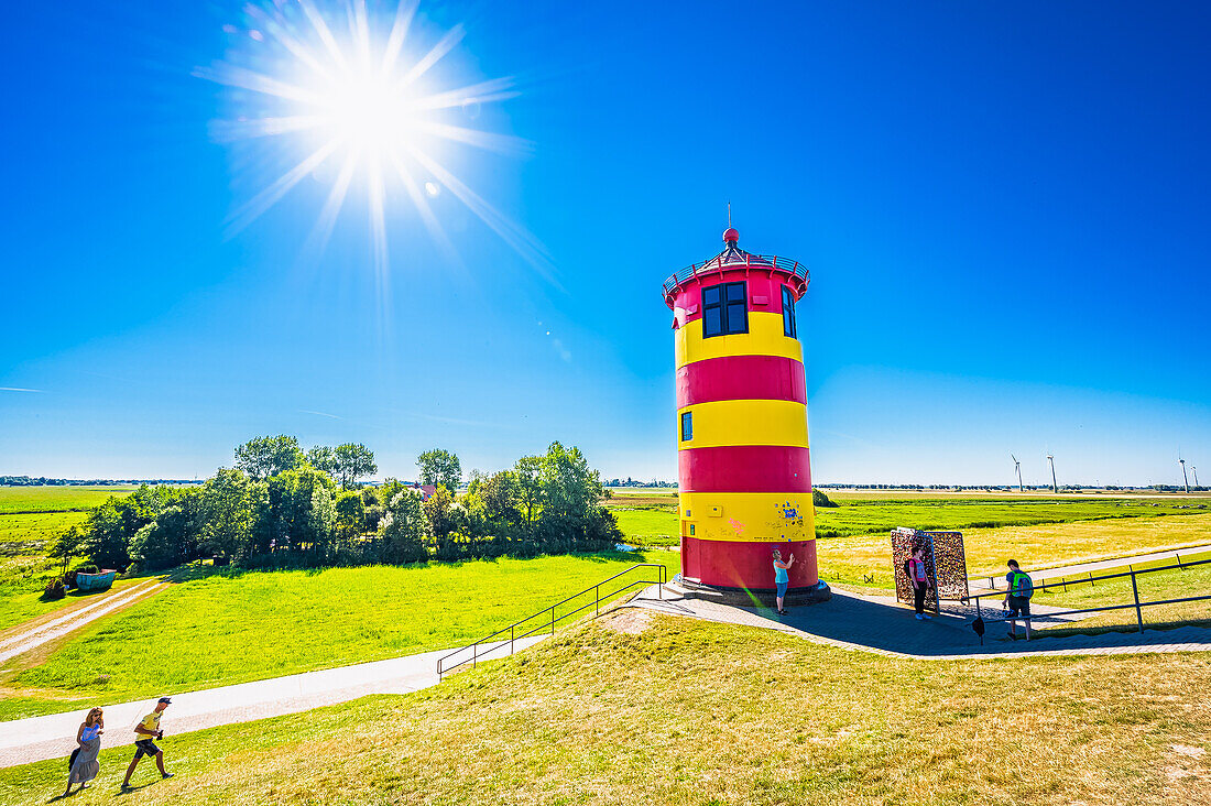 Der Pilsumer Leuchtturm auf dem Nordseedeich im Sommer mit blauem Himmel in der Nähe von Greetsiel, Gemeinde Krummhörn, Niedersachsen, Deutschland