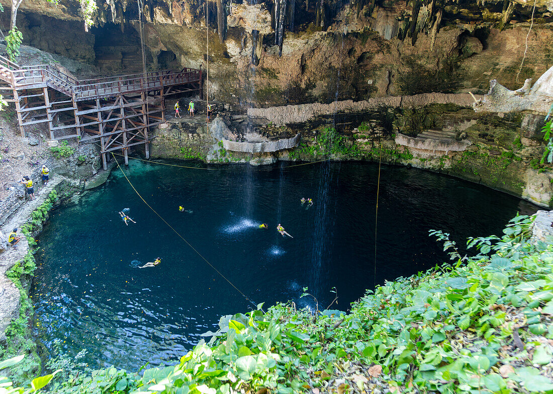People swimming in Cenote Zaci carboniferous limestone swallow hole pool, Vallodolid, Yucatan, Mexico