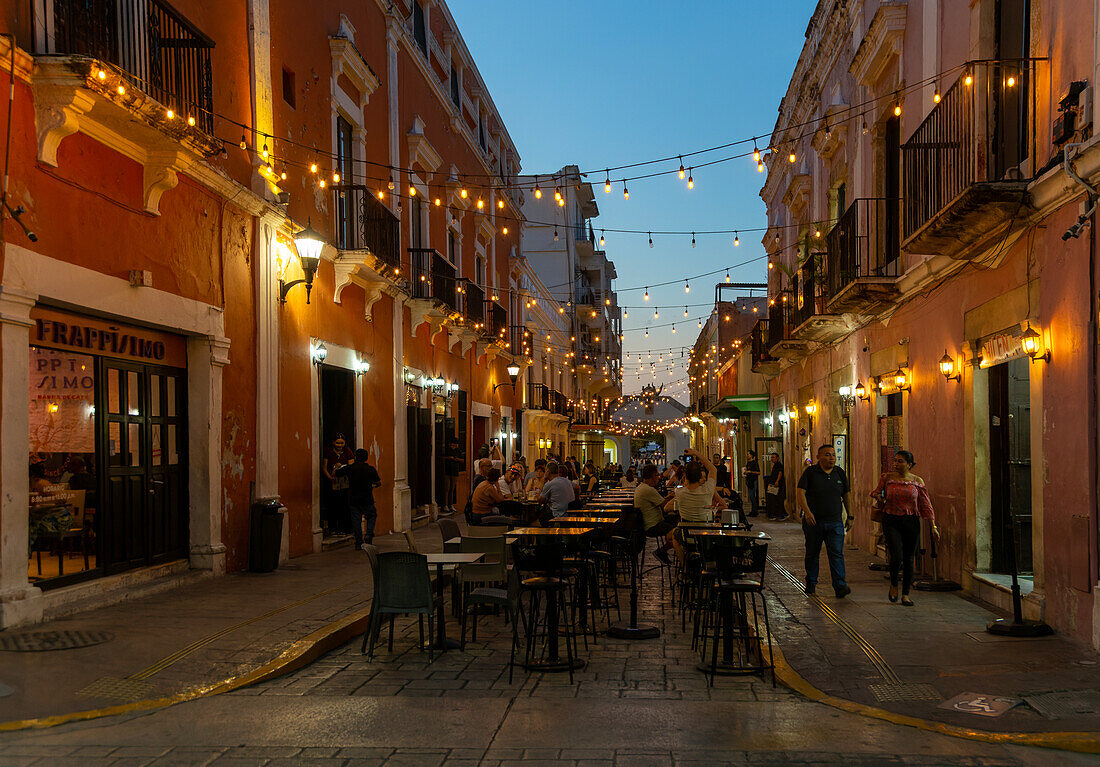 Restaurant tables in street at night with hanging lights, Campeche city, Campeche State, Mexico