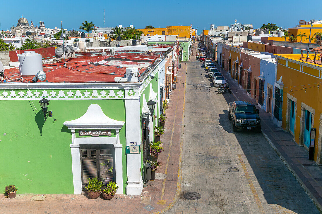 Erhöhte Ansicht der Straße mit geparkten Autos und farbenfrohen spanischen Kolonialgebäuden, Stadtzentrum von Campeche, Bundesstaat Campeche, Mexiko