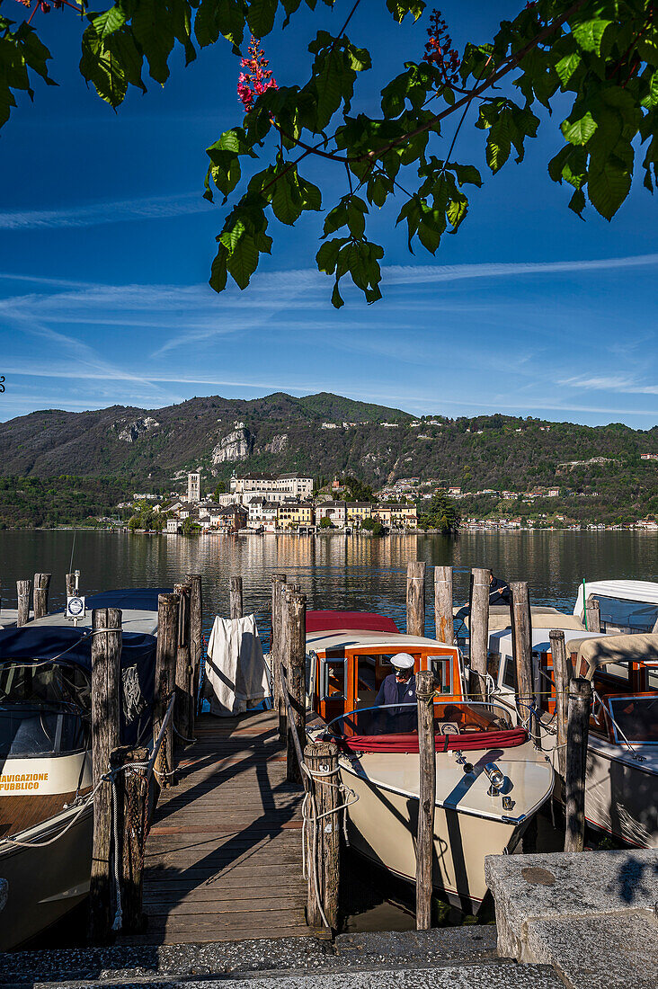  Captain cleaning his water taxi, view of Isola San Giulio from the port of Orta San Giulio, Piazza Motta, Orta San Giulio, Lake Orta is a northern Italian lake in the northern Italian, Lago d&#39;Orta, or Cusio, region of Piedmont, Italy, Europe 