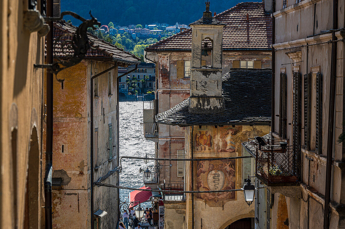 Enge Gasse und Menschen auf der Piazza Motta, Gemeinde Orta San Giulio, Ortasee Lago d’Orta, Provinz Novara, Region Piemont, Italien